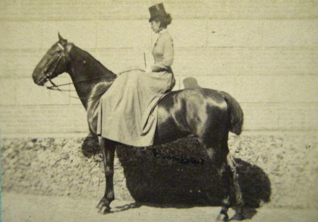 Photo ancienne d'une femme assise sur un cheval